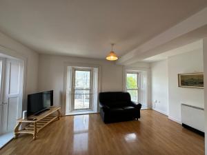 a living room with a black chair and a television at Bridge View Apartment in Waterford