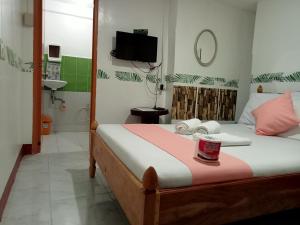 a bedroom with a bed and a bathroom at Ennas Place in Coron