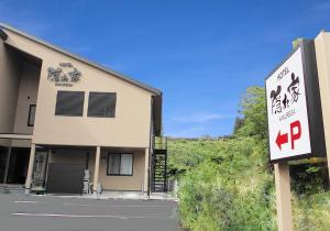 un edificio con una señal delante de él en NARITA HOTEL KAKUREGA - Vacation STAY 69221v en Narita