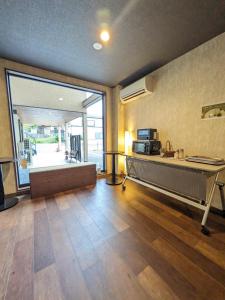 un soggiorno con scrivania e una grande finestra di NARITA HOTEL KAKUREGA - Vacation STAY 69221v a Narita