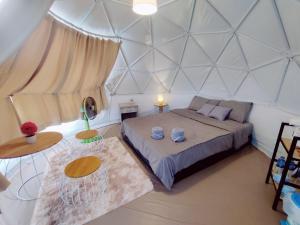 a bedroom with a bed and two tables in a room at ภูชวนหลง ม่อนแจ่ม in Chiang Mai