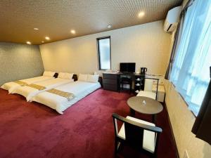 una camera d'albergo con un grande letto e una scrivania di NARITA HOTEL KAKUREGA - Vacation STAY 72264v a Narita