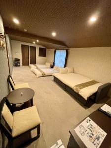 una camera d'albergo con 2 letti, scrivania e sedia di NARITA HOTEL KAKUREGA - Vacation STAY 72264v a Narita