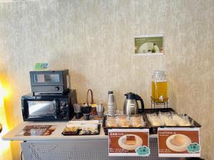un bancone con pasticcini e una macchinetta del caffè. di NARITA HOTEL KAKUREGA - Vacation STAY 72264v a Narita