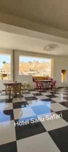 uma sala com mesas e cadeiras num piso xadrez em Hotel Sallu Safari em Jaisalmer