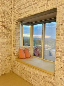 a window seat with two pillows in a brick wall at Lazy Sheeps Hostel in Hengchun South Gate