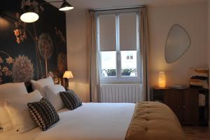 une chambre avec un grand lit blanc et une fenêtre dans l'établissement L'Appart Gîte de Charme, à Compiègne