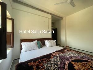 Hotel Sallu Safari في جيلسامر: غرفة نوم بسرير ذو شراشف ووسائد بيضاء