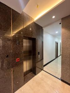 vestíbulo con ascensor y paredes de azulejos marrones en Hotel Rajshree en Agra