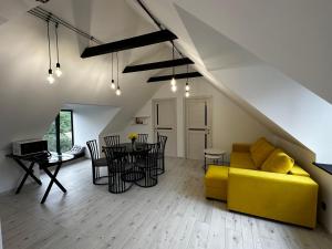 a living room with a yellow couch and a table at Areguni Cottage in Dilijan