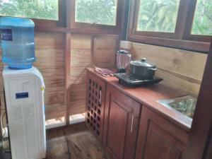 a kitchen with a water heater and a bottle of water at Green Herbal Ayurvedic Eco-Chalets in Galle