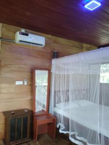 a bedroom with a bed with a white canopy at Green Herbal Ayurvedic Eco-Chalets in Galle