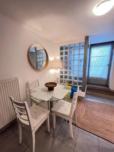 a dining room with a table and chairs and a mirror at Salut Le Petit Gite in Carcassonne