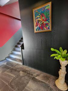 a staircase with a painting and a vase with a plant at Penpark Place in Bangkok