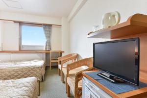 a living room with a large flat screen tv at Kitami Plaza Hotel in Kitami