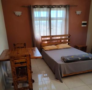 um quarto com uma cama, uma mesa e uma janela em Panoramic Paradise em Rodrigues Island