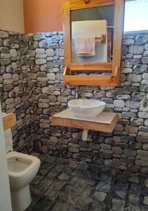 a stone bathroom with a sink and a toilet at Panoramic Paradise in Rodrigues Island