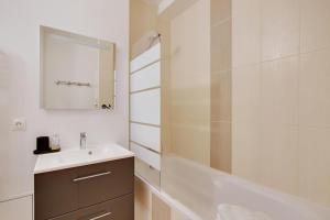 a bathroom with a sink and a shower and a mirror at Maison de la Radio - Tour Effeil in Paris