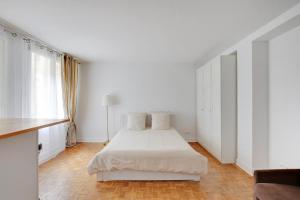 a white bedroom with a bed and a window at Maison de la Radio - Tour Effeil in Paris
