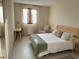 um quarto com uma cama, uma secretária e uma cadeira em Apartamento recién reformado en Ezcaray em Ezcaray