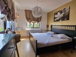 a bedroom with a bed and a chandelier at Villa Dageraad in De Panne