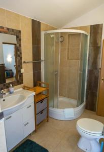 a bathroom with a shower and a toilet and a sink at Apartments Petrica in Baška