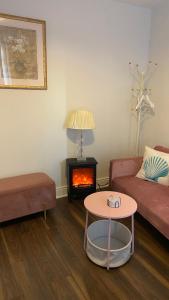 een woonkamer met een bank en een open haard bij Bexhill Stunning 2 bedroom Sea Front Bungalow in Bexhill