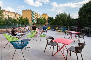 a group of people sitting on a patio with tables and chairs at Bohoostel in Bologna