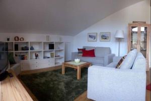 ein Wohnzimmer mit einem Sofa und einem Tisch in der Unterkunft Sonnentau -909- in Mittenwald