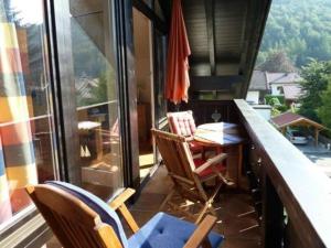einen Balkon mit einem Tisch und Stühlen sowie einem Fenster in der Unterkunft Sonnentau -909- in Mittenwald