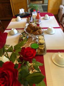 einen Tisch mit Essen und Rosen darauf in der Unterkunft LES PAYRATONS in Saint-Gérand-le-Puy