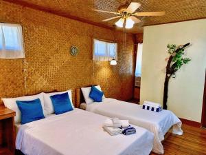 two beds in a room with blue pillows at Peak View Resort in San Vicente