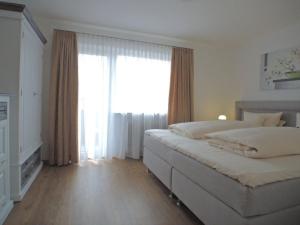- une chambre avec un lit et une grande fenêtre dans l'établissement Rustico -301-, à Mittenwald