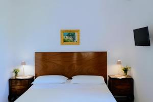 マルターノにあるAgriturismo Villa Colucciaのベッドルーム1室(大型ベッド1台、木製ヘッドボード付)