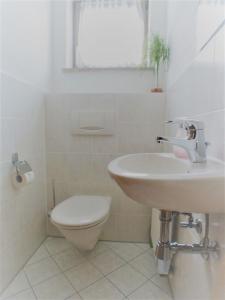 uma casa de banho branca com um lavatório e um WC em Sonnenblume -607- em Mittenwald
