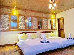 1 dormitorio con 1 cama grande con sábanas y almohadas blancas en Peak View Resort, en San Vicente