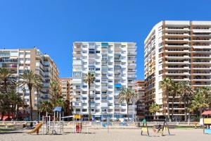 un grupo de edificios altos con palmeras y un parque infantil en MÁLAGA CENTER, MALAGUETA BEACh, en Málaga
