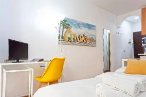 マラガにあるMÁLAGA CENTER, MALAGUETA BEAChのベッドルーム1室(ベッド1台、黄色い椅子付)
