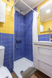 baño de azulejos azules con ducha y aseo en MÁLAGA CENTER, MALAGUETA BEACh, en Málaga