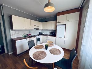 cocina con mesa blanca y sillas en una habitación en STAY Matinkatu Apartment, en Espoo 3 fotos más