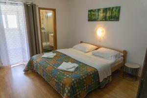a bedroom with a bed with two towels on it at Apartments Petrica in Baška
