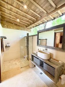 een badkamer met een wastafel en een spiegel bij Nusava Boutique Hotel in Nusa Penida