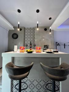 a kitchen with a counter and two stools at VIP Apt. Pezodromos Kalamarias in Thessaloniki