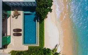 an overhead view of a swimming pool next to the beach at Fisherman Way Beach Villa in Rawai Beach