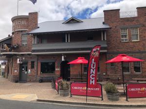 a restaurant with red umbrellas in front of a building at COMMERCIAL HOTEL KANIVA in Kaniva