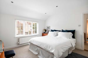 a white bedroom with a large white bed and a window at Beautiful Apartment Wendens Ambo in Wendens Ambo