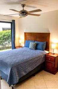 a bedroom with a bed and a ceiling fan at The Beach House Ground Floor Condo in Coco +42 photos