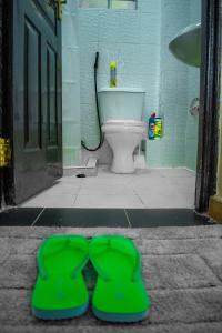 a bathroom with a toilet and a green pair of mittens at Urban Elegance in Nairobi +22 photos