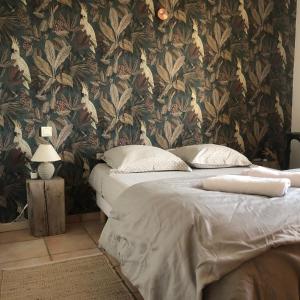 two twin beds in a bedroom with a floral wallpaper at Belle maison provençale au pied du Mont Ventoux in Caromb