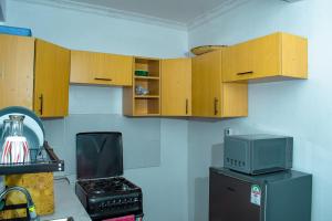 a kitchen with wooden cabinets and a microwave at Urban Elegance in Nairobi